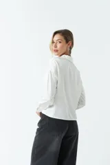 Camisa blanca de satén con corte relajado y largo a la cadera.