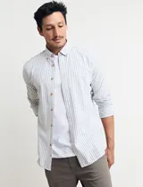 Camisa sport de algodón con cuello button-down y manga larga. Diseño a rayas verticales en tonos gris y blanco. Cierre frontal con botones de madera.