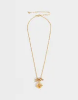 Collar corto dorado con cadena de eslabones y dijes colgantes: libélula, anillos y flor con centro de cristal rosado.