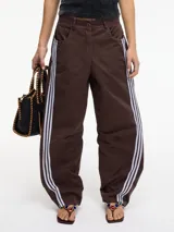 Pantalón slouchy marrón de tiro alto con cierre de botón y cremallera, pretina con pasacinto y rayas blancas laterales.