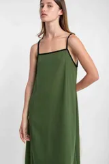 Vestido largo verde oliva de lino, con breteles finos negros y escote cuadrado con ribete negro.