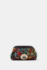 Bolso de mano con cuerpo en abalorios negros y diseño floral multicolor. Tiene asa de anillas metálicas extraíble en forma de bandolera, bolsillo interior y forro interior. Cierre mediante clip.