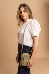 Bandolera compacta de símil cuero color rojo, con correa regulable y desmontable. Posee apertura superior, bolsillo frontal con cierre y bolsillo trasero abierto.