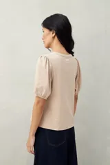 Remera negra de algodón con mangas abullonadas y elástico en la terminación.