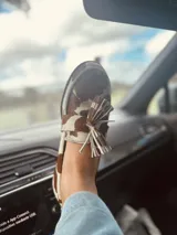 Alpargatas tipo mocasín de gamuza color amarillo mostaza, con detalle de flecos en la capellada.