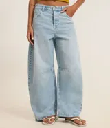 Pantalón de jean celeste, modelo barrel, con trabillas en la cintura, bolsillos y detalle de recorte en la entrepierna.