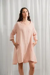 Vestido corto de lino color rosado, corte ancho y mangas 3/4, con escote en V.