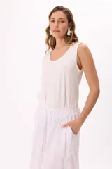 Musculosa negra de algodón liviano, suave y fresco, con cuello amplio y terminaciones sutiles.