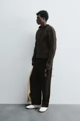 Sweater marrón oscuro de punto con estructura de trenzas, cuello redondo, manga larga y corte regular fit.