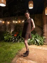 Vestido corto marrón con rayas verticales negras y volados en el ruedo.