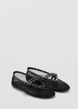 Zapato tipo ballerina color negro, de tejido de malla con detalles troquelados y doble tira con cierre de hebilla.