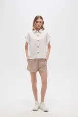Camisa blanca de algodón con cuello clásico, manga corta con botón y cierre frontal con botones de carey.