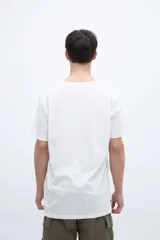 Remera color crudo con estampa frontal con texto en color ocre.