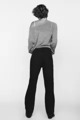 Pantalón de jean negro de tiro alto, corte recto, con cinco bolsillos y cierre frontal con cremallera y botón metálico.