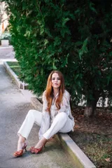 Zapato de tacón destalonado con estampado animal print en tonos naranja y marrón, con lazo doble en la parte delantera y tira trasera con hebilla. Tacón cuadrado de 2,5 cm y suela de cuero.