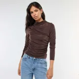 Camiseta marrón de material fluido con cuello alto y mangas largas.