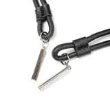 Cartera bandolera negra de símil cuero graneado con cordón de ajuste. Tiene correa regulable, herrajes plateados, un bolsillo interno con cierre y dos abiertos.