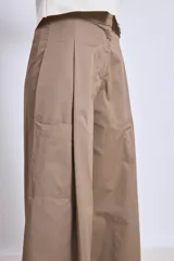 Pantalón palazzo color marrón claro, de tiro alto, con pinzas y bolsillos laterales.