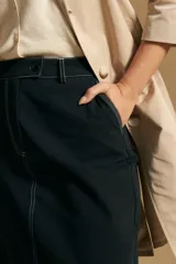 Falda larga de mezclilla color crema, de corte recto y talle alto, con costuras visibles en contraste y abertura frontal.