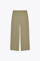 Pantalón color verde oliva de tiro alto, corte ancho y largo 7/8. Tiene cintura elástica ajustable con cordón, bolsillos de plastrón en delantero y espalda.