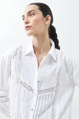Camisa blanca de manga larga con detalles de encaje en el frente y las mangas.
