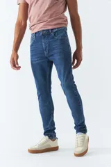 Pantalón de jean skinny azul oscuro, tiro medio, con logo bordado y pasacinto.