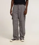 Pantalón paper touch color verde militar, con bolsillos laterales, cintura elástica y cordón de ajuste. Se convierte en bermuda gracias a un cierre a la altura de la rodilla.