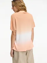 Remera color durazno con degradé blanco, de punto con escote en V y mangas cortas.
