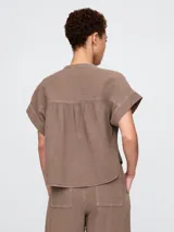 Camisa de muselina color blanco, con cuello mao y mangas cortas.