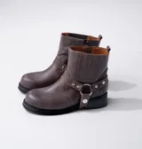 Bota corta negra de cuero vacuno con estribo desmontable, suela de caucho, cierre interno y punta redonda.