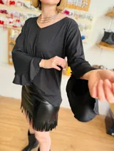 Blusa negra con escote en V y mangas largas acampanadas con volados.