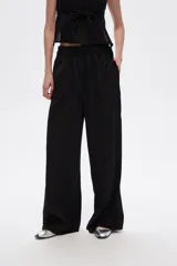 Pantalón negro de viscosa, corte ancho y tiro alto, con elástico en la cintura y bolsillos laterales.