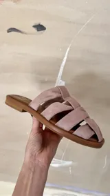 Sandalias bajas color rosa viejo con tiras de cuero entrelazadas y suela marrón.