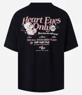 Remera negra de corte oversized con estampa en la espalda con la frase "Heart Eyes Only" y un oso cupido.