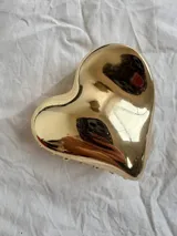 Pinza de pelo dorada con forma de corazón.