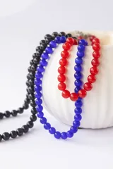 Collar corto de cuentas redondas de vidrio color naranja.