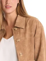 Chaqueta de efecto gamuza color marrón, con cuello solapa, cierre frontal con botones y bolsillos delanteros. Presenta costuras desplazadas en los hombros para un calce relajado y forro interno a tono.