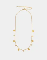 Collar corto dorado con cadena de eslabones pequeños, dijes de trébol de cuatro hojas y dijes redondos con cristales engarzados.