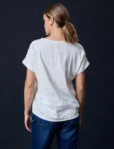 Blusa color blanco de lino marca Cable & Gauge, con aplique de botones en los hombros.