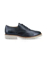 Zapato Oxford color bronce con detalles de perforaciones y suela blanca de goma.