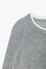 Jersey de punto color beige con cuello redondo y manga larga.