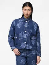 Camisa de jean azul con estampado de rosas, corte holgado, cuello clásico, cierre con botones y dos bolsillos frontales con solapa.