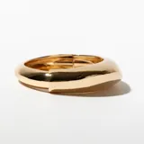 Brazalete rígido dorado con forma ovalada.