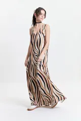 Vestido largo con estampado abstracto en tonos marrón, negro y blanco, escote en V y corte suelto.