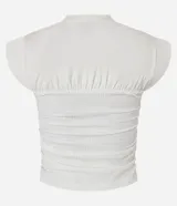 Blusa color crema con cuello redondo y mangas cortas. Presenta un recorte texturizado en el busto y está confeccionada en algodón.