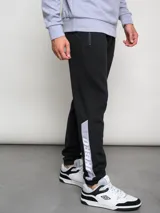 Pantalón de jogging negro con puños ajustados, cortes laterales y cambio de color en la parte inferior de la pierna.