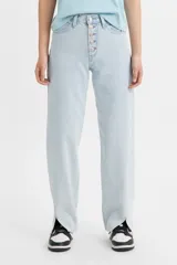 Pantalón jean celeste de corte ancho, con tiro medio, cierre con botones y aberturas en el ruedo.