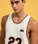 Musculosa de punto color crema con cuello redondo y bies contrastante en marrón. Presenta el número 23 estampado en el frente y un pequeño logo con una estrella.