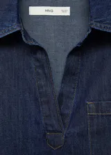 Camisa de jean azul oscuro, de corte holgado, manga larga y cuello clásico con abertura en V.