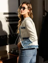 Chaqueta Nanette en tejido tweed color blanco y denim azul. Tiene cuello a la base, abertura central, bolsillos delanteros, puños con aplique de botones perlados, terminación desflecada y forro interno.